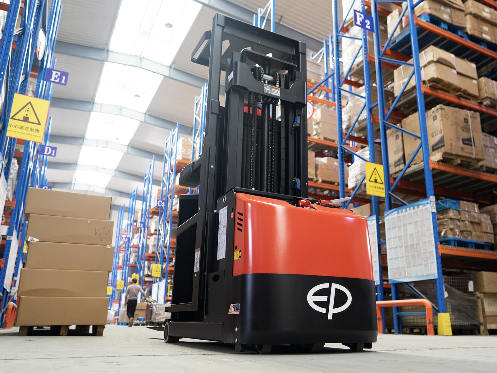 Electric stacker lifting crates in narrow aisle