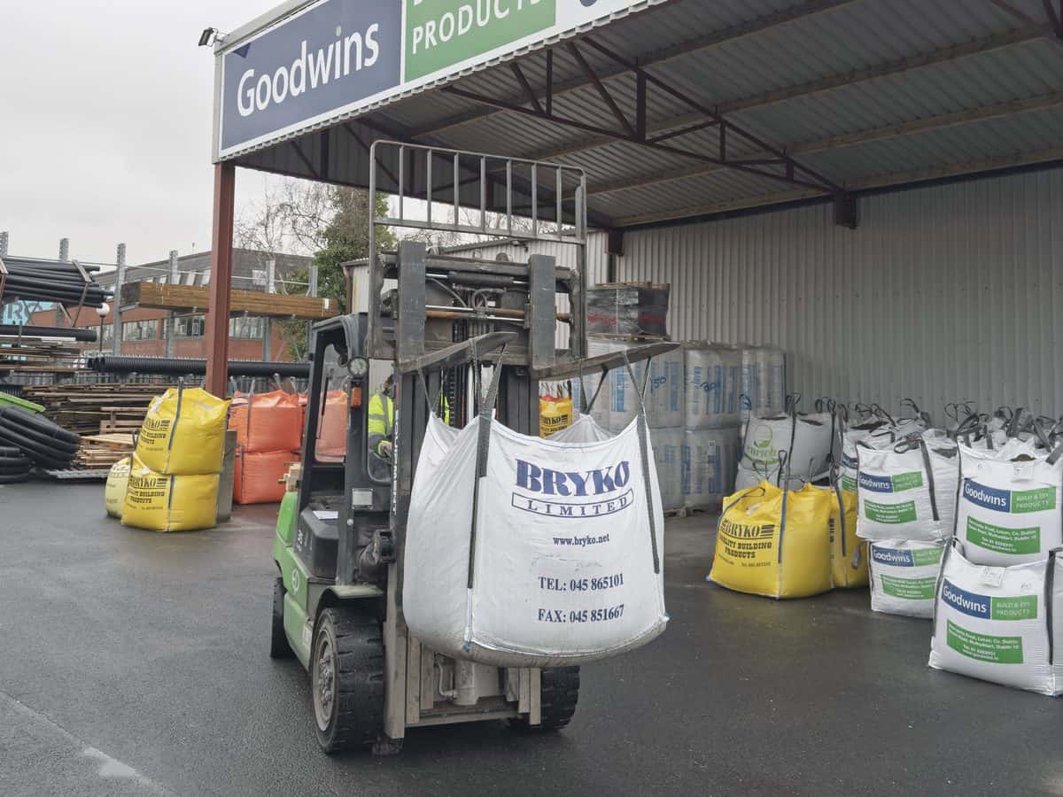 Green EP lithium-ion forklift carrying a bulk bag under a builders merchant canopy