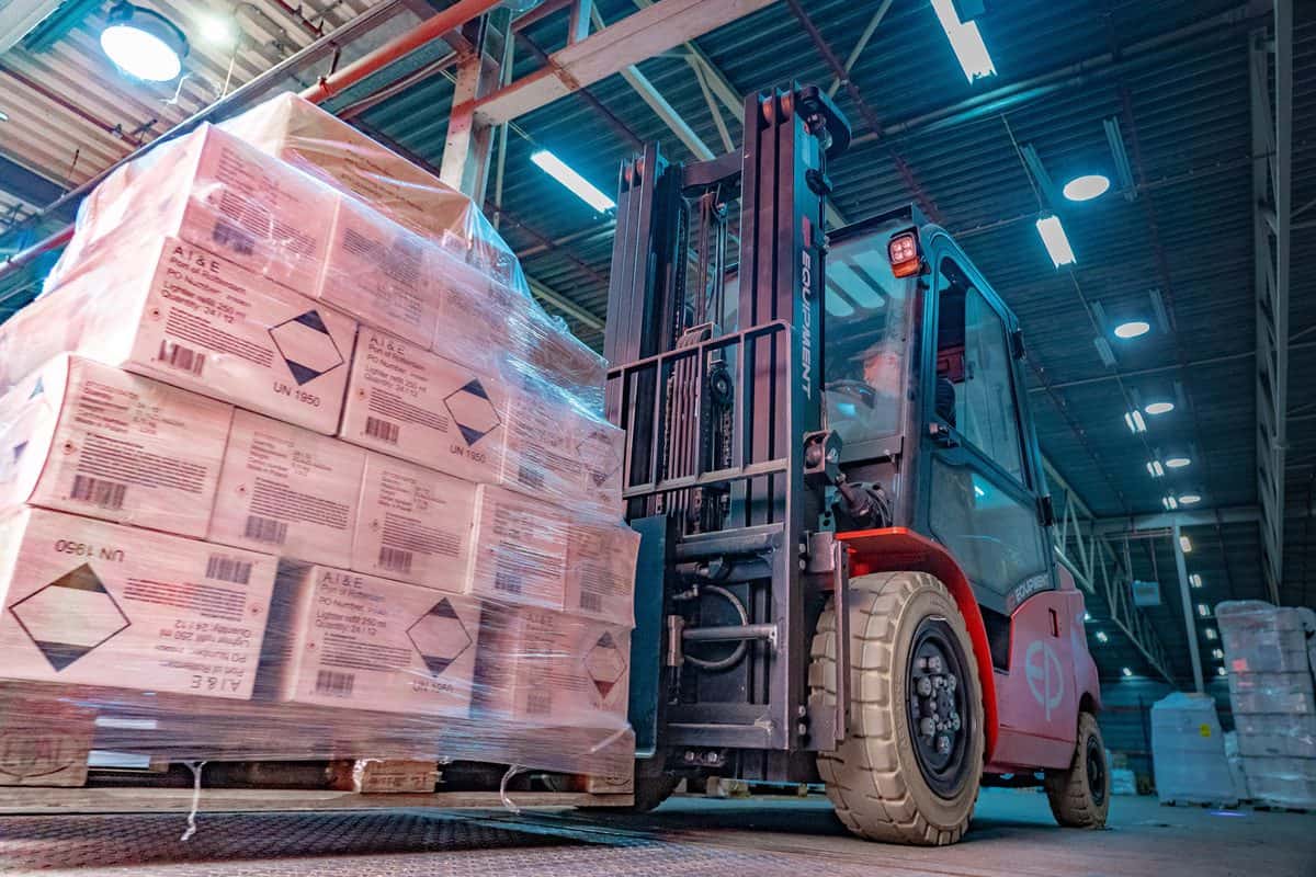 EP compact 4-wheel electric forklift lifting a wrapped pallet in a warehouse