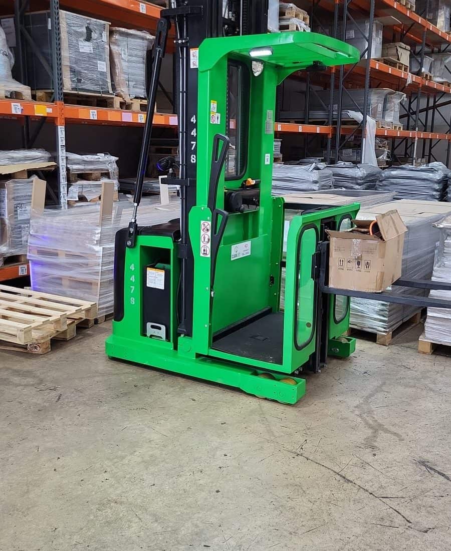 Green EP order picker with its platform raised beside warehouse racking