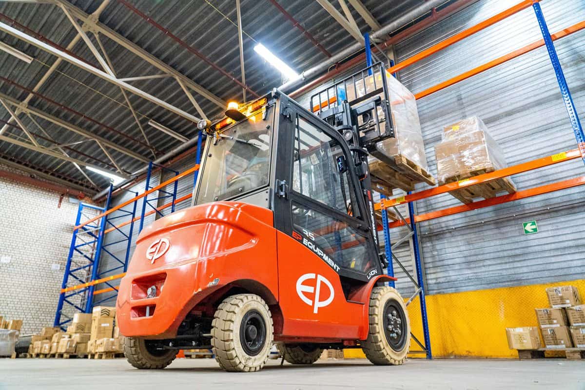 EP electric forklift with an enclosed cab working between warehouse racking