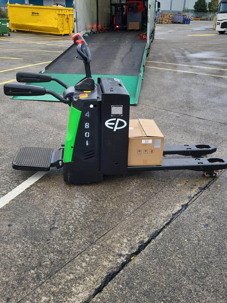 Green EP ride-on pallet truck coming off a delivery trailer