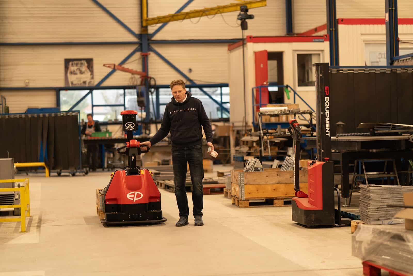 Operator beside an EP XP15 co-bot pallet truck that drives manually or automatically